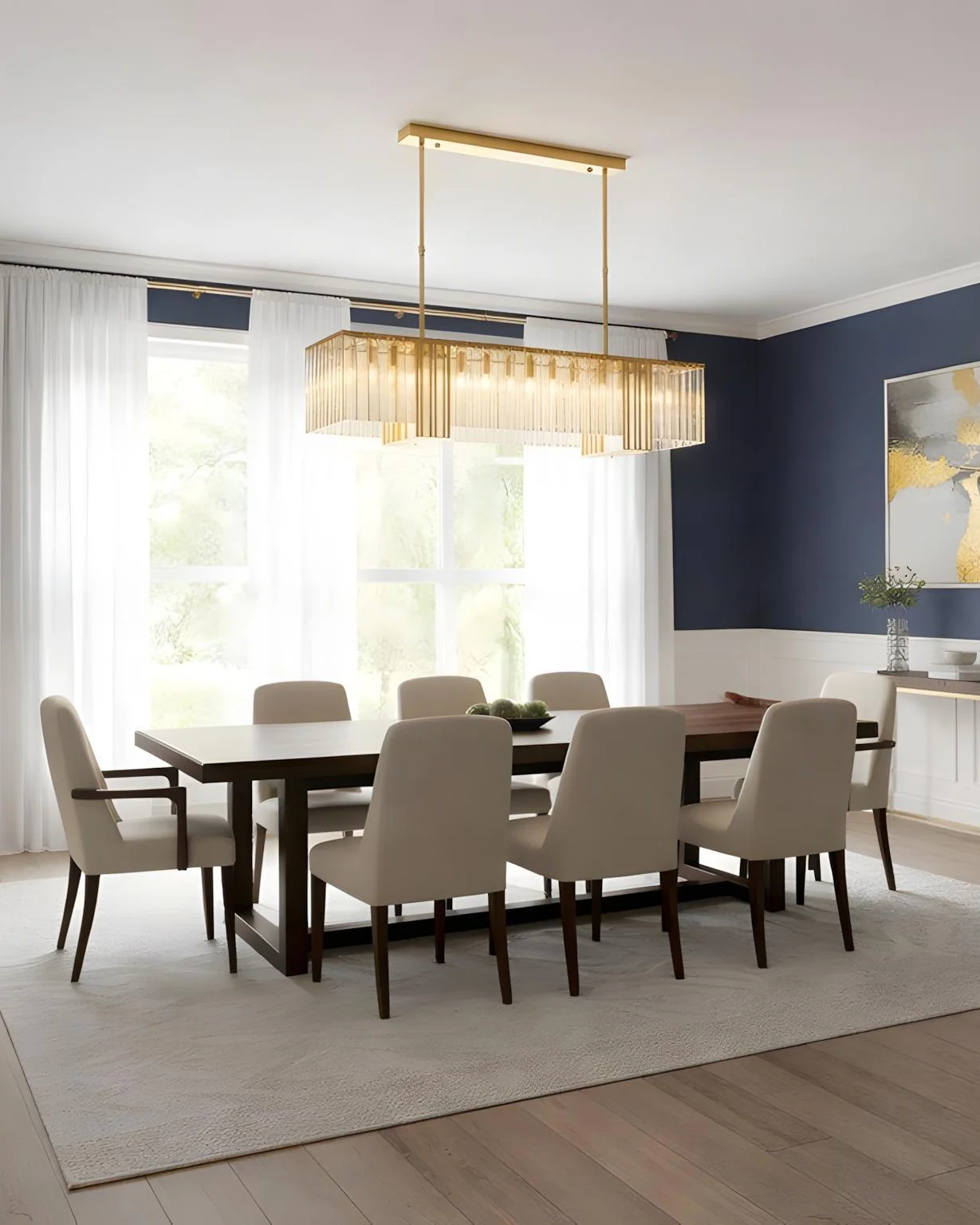 A golden crystal linear chandelier above a long dining table