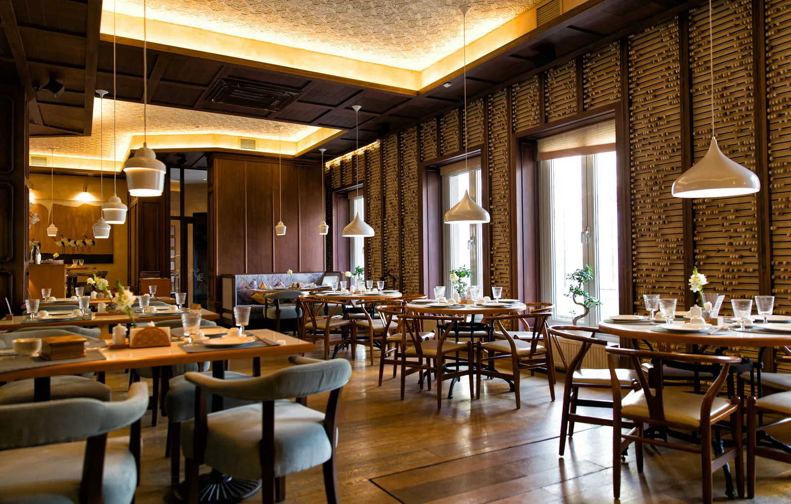 Restaurant dining room with warm cove lighting and pendant lights