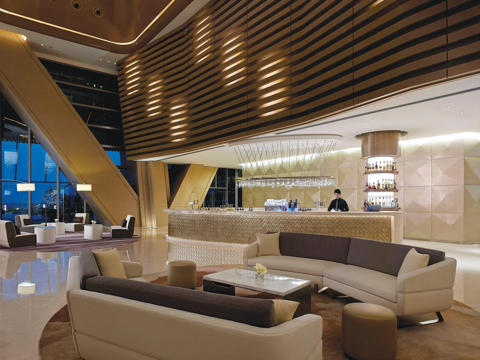 Hotel lobby bar with indirect light glowing through slatted timber walls