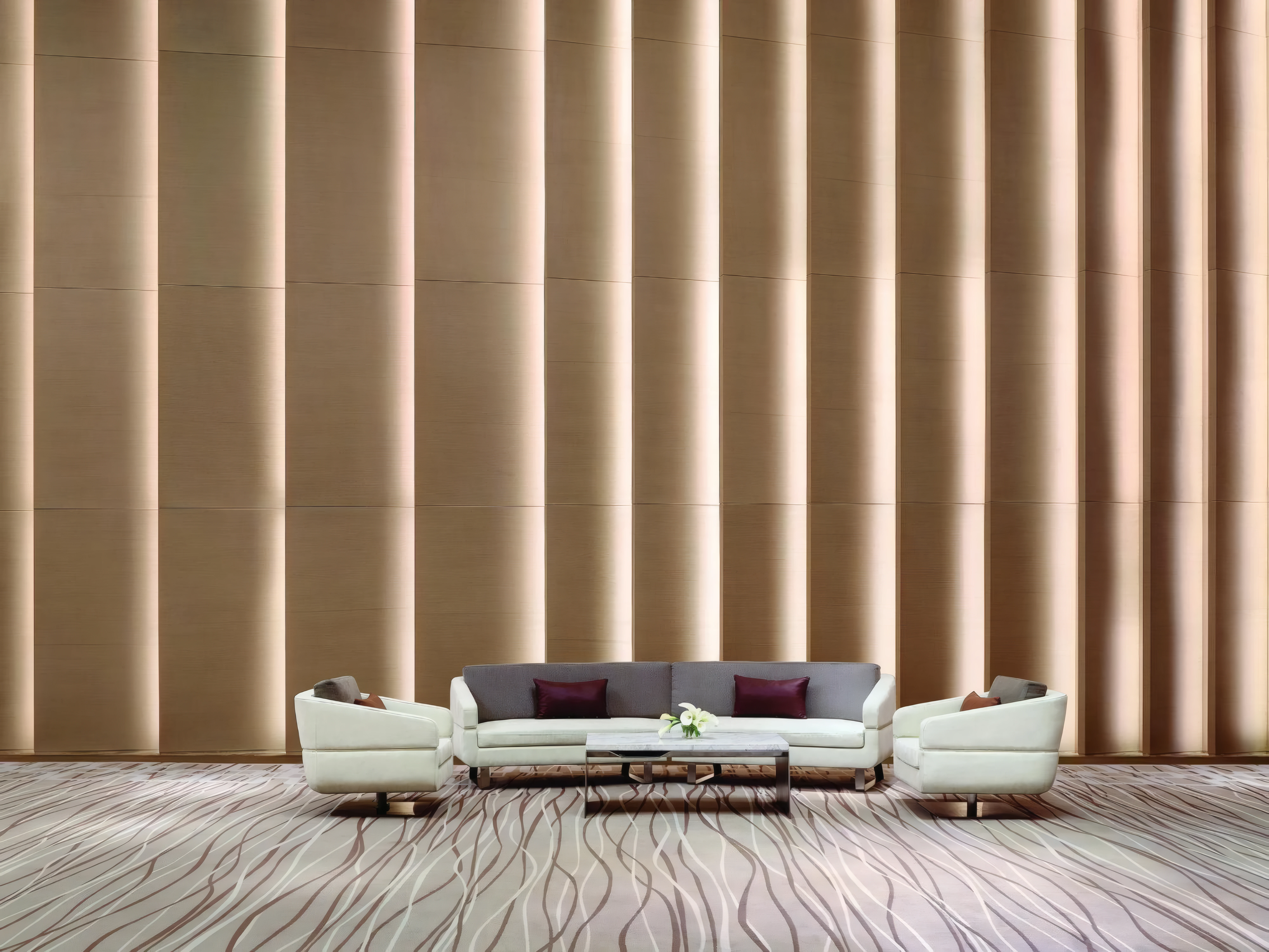 Hotel lobby with a wall of vertical LED-lit panels behind low sofas