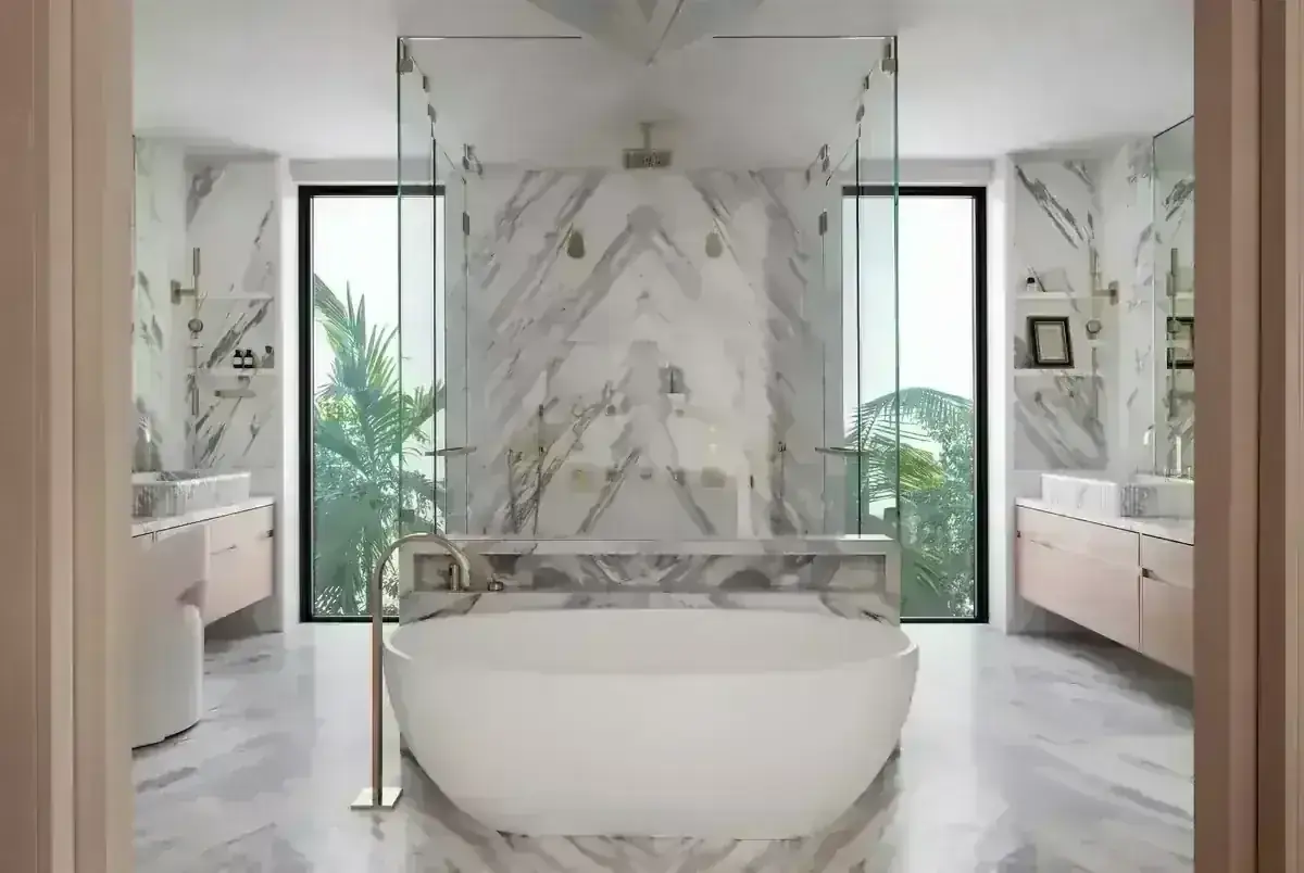 Freestanding bath and floor-standing mixer in a marble bathroom