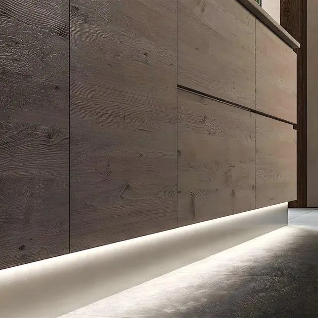 Timber-clad wall with a line of light washing the floor from the skirting